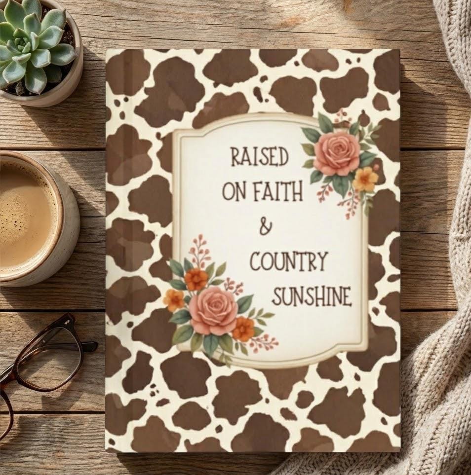 The journal sitting on a wooden table next to a cup of coffee and a green plant, emphasizing the cozy western aesthetic.